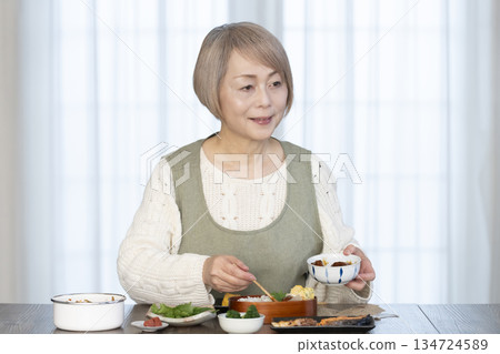 Senior woman making lunch in the kitchen Senior woman making lunch in the kitchen 134724589