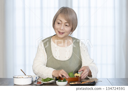 Senior woman making lunch in the kitchen Senior woman making lunch in the kitchen 134724591