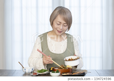 Senior woman making lunch in the kitchen Senior woman making lunch in the kitchen 134724596