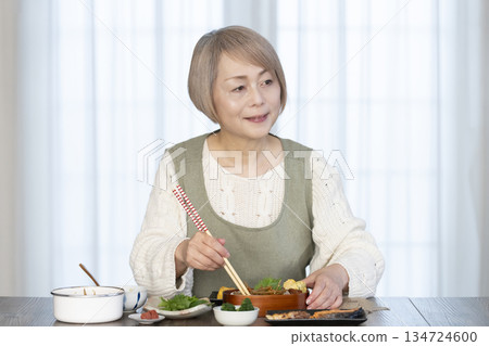 一位老婦人在廚房做午餐 一位老婦人在廚房做午餐 134724600