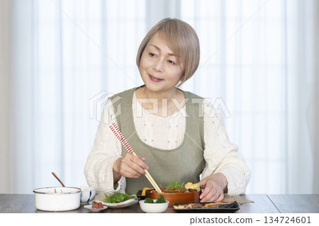 一位老婦人在廚房做午餐 一位老婦人在廚房做午餐 134724601