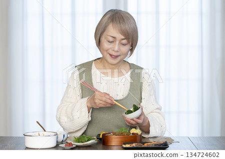 Senior woman making lunch in the kitchen Senior woman making lunch in the kitchen 134724602
