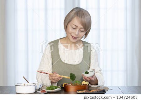 Senior woman making lunch in the kitchen Senior woman making lunch in the kitchen 134724605