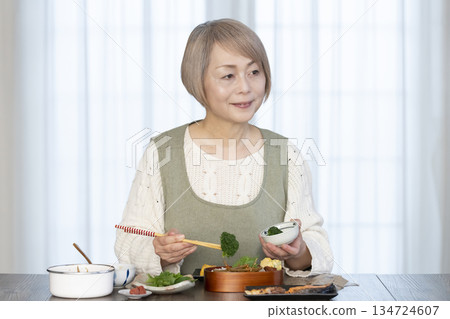 Senior woman making lunch in the kitchen Senior woman making lunch in the kitchen 134724607