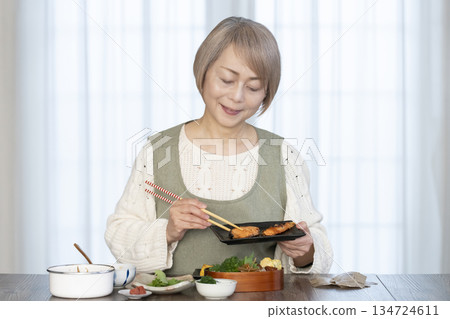 Senior woman making lunch in the kitchen Senior woman making lunch in the kitchen 134724611