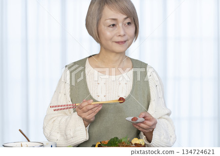 一位老婦人在廚房做午餐 一位老婦人在廚房做午餐 134724621