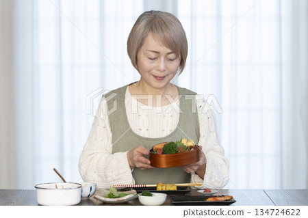Senior woman making lunch in the kitchen Senior woman making lunch in the kitchen 134724622