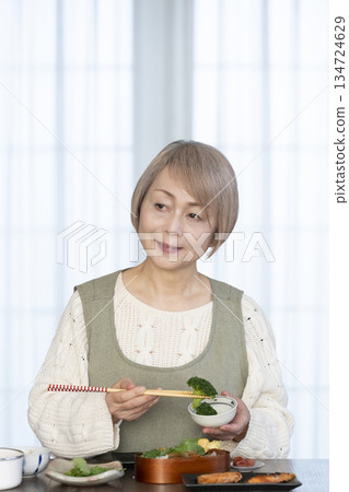 Senior woman making lunch in the kitchen Senior woman making lunch in the kitchen 134724629
