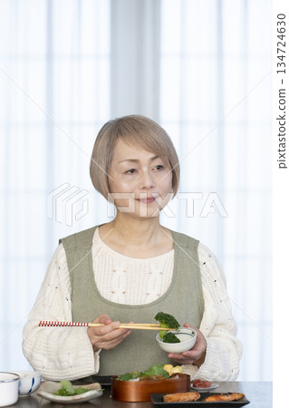 Senior woman making lunch in the kitchen Senior woman making lunch in the kitchen 134724630