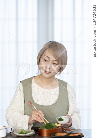 Senior woman making lunch in the kitchen Senior woman making lunch in the kitchen 134724632