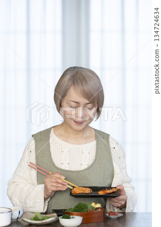 Senior woman making lunch in the kitchen Senior woman making lunch in the kitchen 134724634