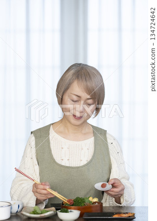 Senior woman making lunch in the kitchen Senior woman making lunch in the kitchen 134724642