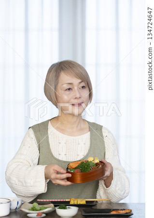 Senior woman making lunch in the kitchen Senior woman making lunch in the kitchen 134724647