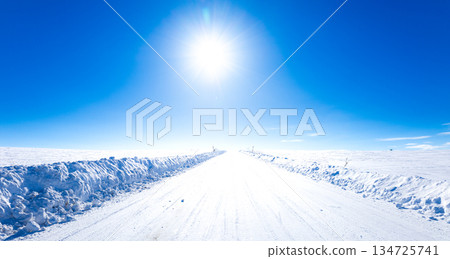 北海道美瑛的冬季景色，藍天白雲，陽光燦爛，積雪厚實，道路結冰。 134725741
