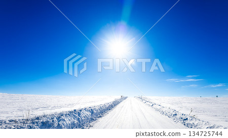 北海道美瑛的冬季景色，藍天白雲，陽光燦爛，積雪厚實，道路結冰。 134725744