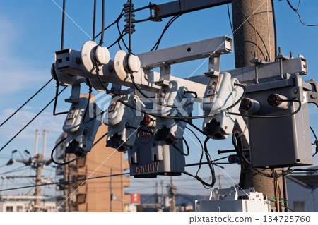 High-voltage cutout on utility pole, 6600V pole-mounted transformer, and details of power distribution equipment seen from the footbridge 134725760