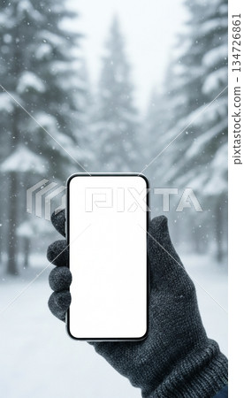 Mockup image of a hand holding a smartphone with a white screen in the winter forest Mockup image of a hand holding a smartphone with a white screen in the winter forest 134726861