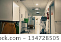French hospital corridor with medical equipment and staff trolley. Text on the sign in French: Exit 134728505