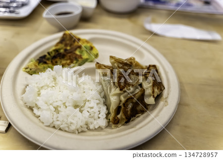 盤子裡盛著煎餃和玉子燒（捲蛋）。 134728957