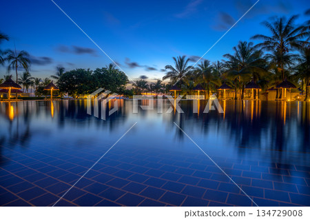 Resort swimming pool in Mauritius with palm trees and lights after sunset. 134729008