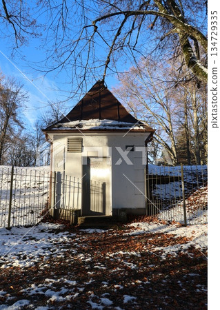 Small building in winter with snow and bare trees 134729335