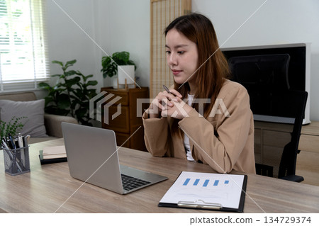 Businesswoman thinking and using computer working in office for business 134729374