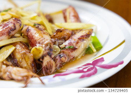 Asian stir-fry dish: Stir-fried baby squid with a glossy sauce and tender, bouncy texture. 134729405