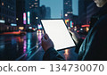 Tablet with a blank white screen in heavy rain. Moody atmosphere, realistic hands with sleeves, concept of technology in challenging environments, digital business, and professional stock illustration 134730070