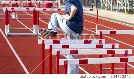 Young Athlete Practices Hurdles Drills on a Track Young Athlete Practices Hurdles Drills on a Track 134730242