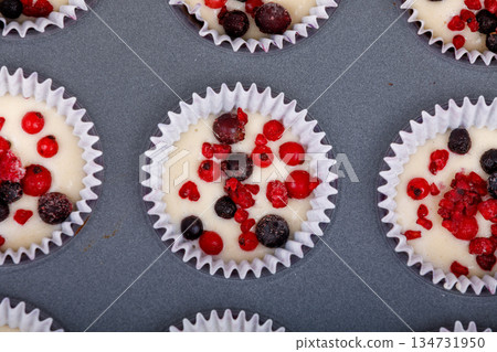 Berry muffins in a baking tray ready to go in the oven. 134731950
