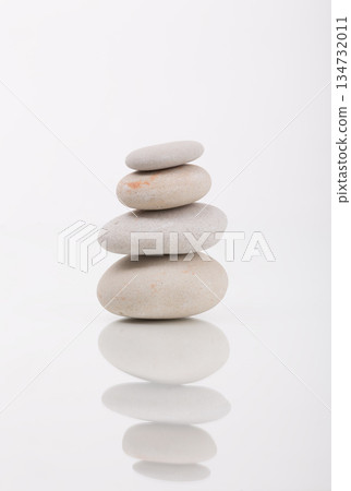 Stacked Balanced Spa Stones on White Reflective Surface 134732011