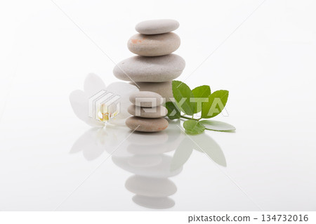 Zen Stones Stack with Orchid Blossom and Green Leaves Zen Stones Stack with Orchid Blossom and Green Leaves 134732016