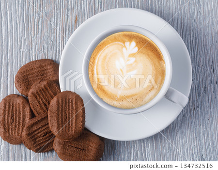 Cappuccino with latte art and chocolate biscuits on wooden table Cappuccino with latte art and chocolate biscuits on wooden table 134732516