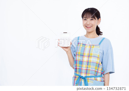 一位微笑的家庭主婦拿著計算器 134732871