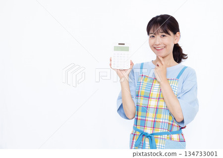 A housewife thinking with a smile while holding a calculator A housewife thinking with a smile while holding a calculator 134733001