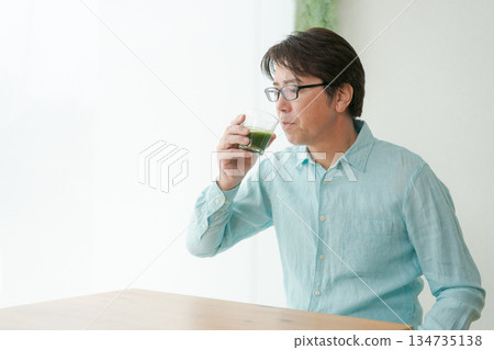 Male drinking green juice Male drinking green juice 134735138