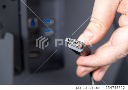 Person holds DisplayPort cable connector, ready to plug into modern computer ports, highlighting digital connectivity and high-resolution display setup Person holds DisplayPort cable connector, ready to plug into modern computer ports, highlighting digital connectivity and high-resolution display setup 134735312