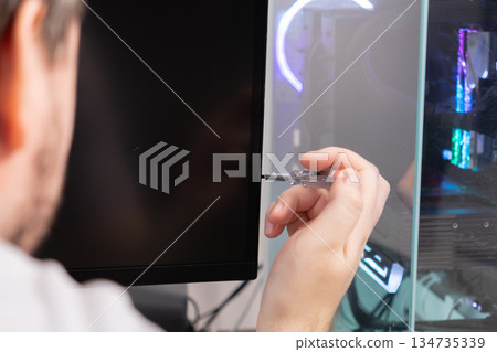 Technician's hand using a precise voltage tester tool on a computer monitor, symbolizing detailed electronics diagnostics, complex hardware troubleshooting, and expert repair Technician's hand using a precise voltage tester tool on a computer monitor, symbolizing detailed electronics diagnostics, complex hardware troubleshooting, and expert repair 134735339
