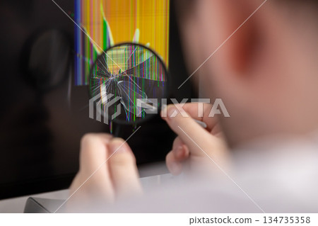 Person examines severely damaged monitor screen with magnifying glass, revealing shattered display and colorful malfunction lines, symbolizing urgent technology repair Person examines severely damaged monitor screen with magnifying glass, revealing shattered display and colorful malfunction lines, symbolizing urgent technology repair 134735358