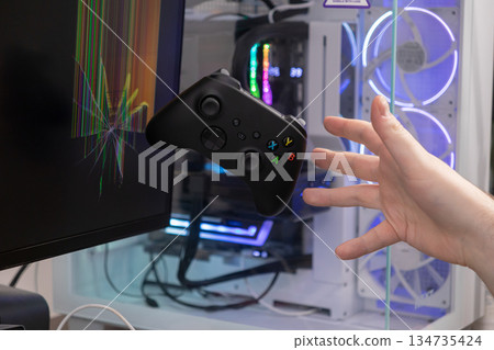 Gaming controller floating near a cracked computer monitor and reaching hand, symbolizing frustration, broken technology, and rage quitting during an intense game Gaming controller floating near a cracked computer monitor and reaching hand, symbolizing frustration, broken technology, and rage quitting during an intense game 134735424