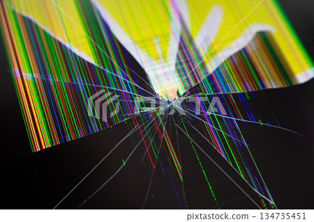 Cracked electronic screen with radiating shatter lines and vibrant distorted multicolored pixels, symbolizing digital technology breakdown, damage, and urgent repair Cracked electronic screen with radiating shatter lines and vibrant distorted multicolored pixels, symbolizing digital technology breakdown, damage, and urgent repair 134735451