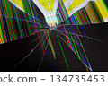 Broken LCD screen with spiderweb cracks and vibrant multicolored vertical pixel lines, signifying electronic device failure, repair, and digital data disruption 134735453