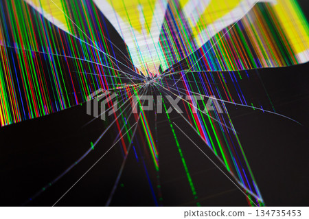 Broken LCD screen with spiderweb cracks and vibrant multicolored vertical pixel lines, signifying electronic device failure, repair, and digital data disruption 134735453