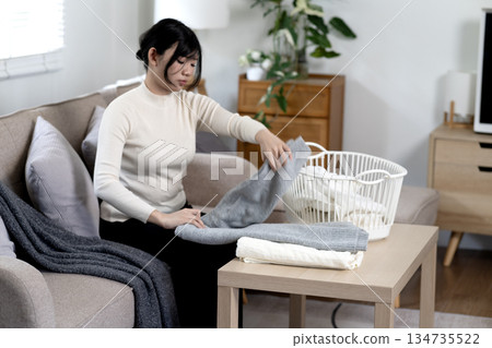 Young woman doing her own housework or housework folding washed 134735522
