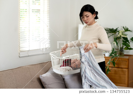 Young woman doing her own housework or housework folding washed 134735523