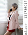 Smiling elder businesswoman stand talking on her mobile phone 134736017