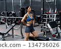 young woman is standing and resting on Wipe the sweat  an exercise machine 134736026