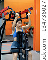 Young woman's fitness exercise with dumbbells gym equipment in the gym promotes a healthy lifestyle 134736027