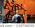 Young woman's fitness exercise with dumbbells gym equipment in the gym promotes a healthy lifestyle 134736030
