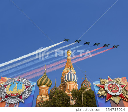 Temple of Basil the Blessed with orders of victory in honor of Victory Day and Russian military aircraft with painted russian flag. Moscow, Russia. Translation: USSR, Victory!, Patriotic war Temple of Basil the Blessed with orders of victory in honor of Victory Day and Russian military aircraft with painted russian flag. Moscow, Russia. Translation: USSR, Victory!, Patriotic war 134737024